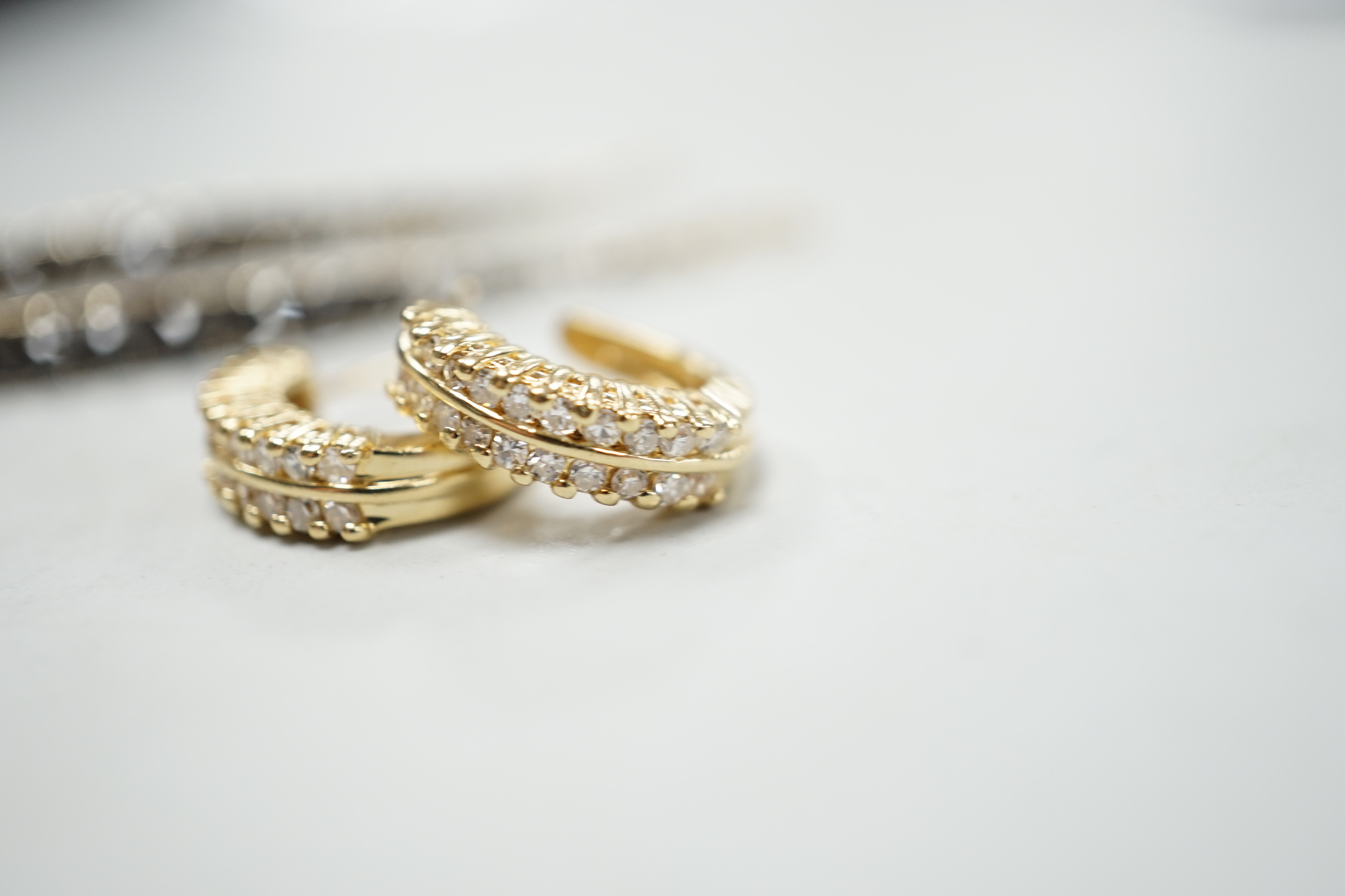A modern pair of 14k yellow metal and two row diamond chip set half hoop earrings, 14mm, gross weight 4.6 grams, together with a modern pair of 18ct gold and two colour diamond set line earrings, 47mm, gross weight 5.3 g